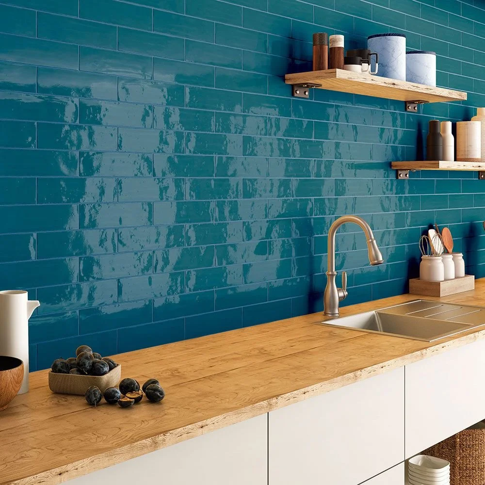Kitchen with a blue tiled wall, wooden countertop, and open shelves holding jars and utensils.