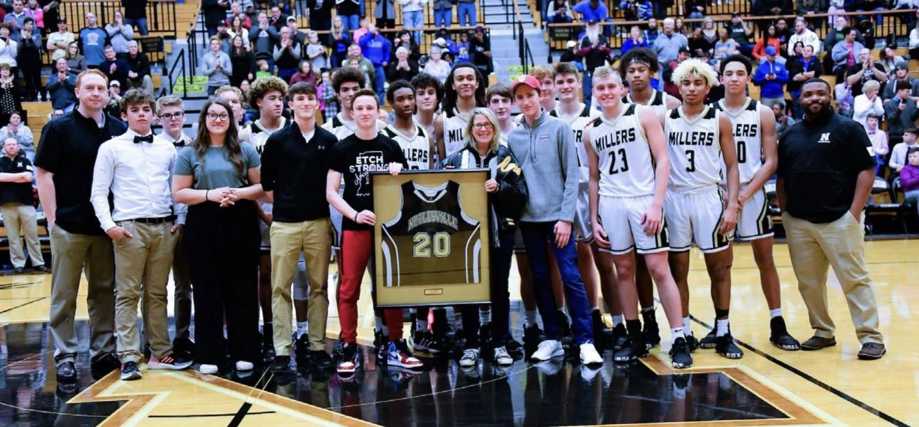 A group of basketball players, coaches, and supporters