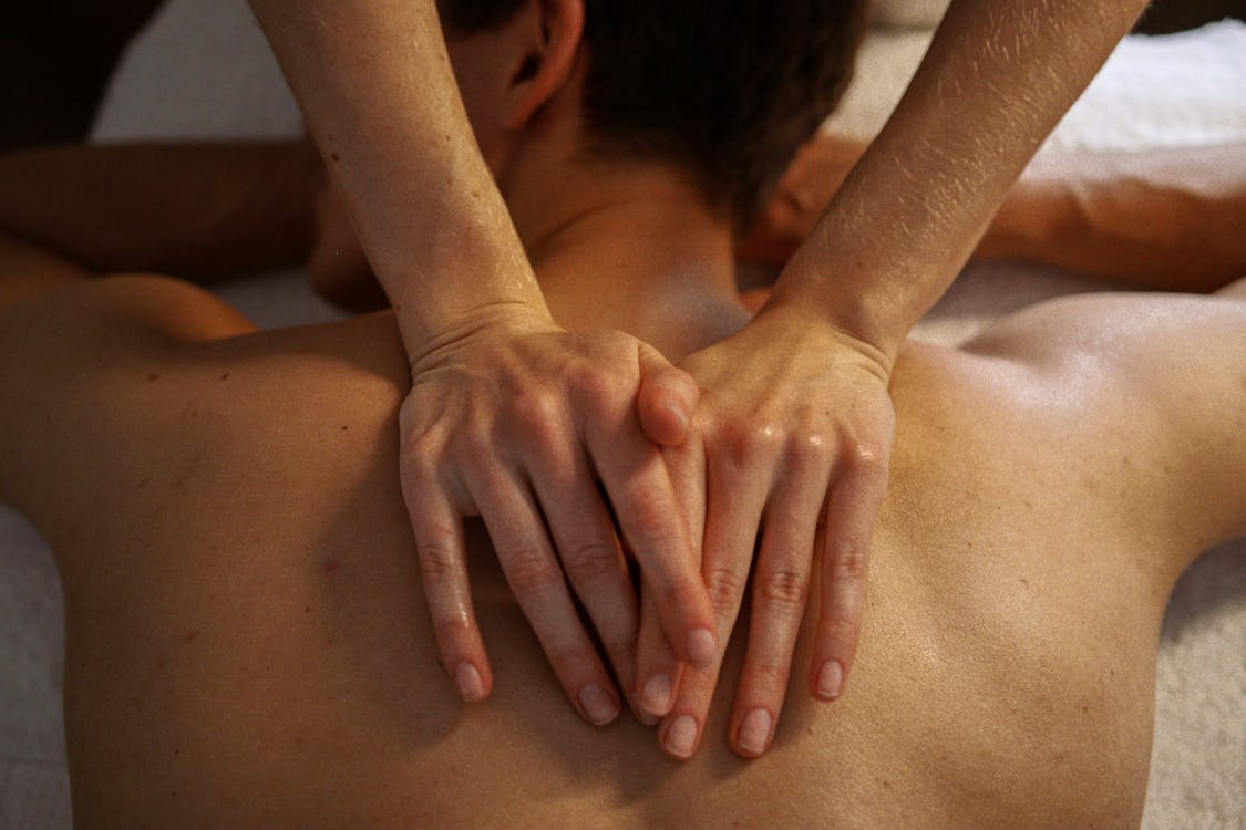 Eine Person erhält eine Rückenmassage auf einem Massagebett.