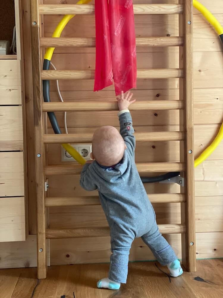 Kind beim Klettern an der Sprossenwand in der Kinderphysiotherapie