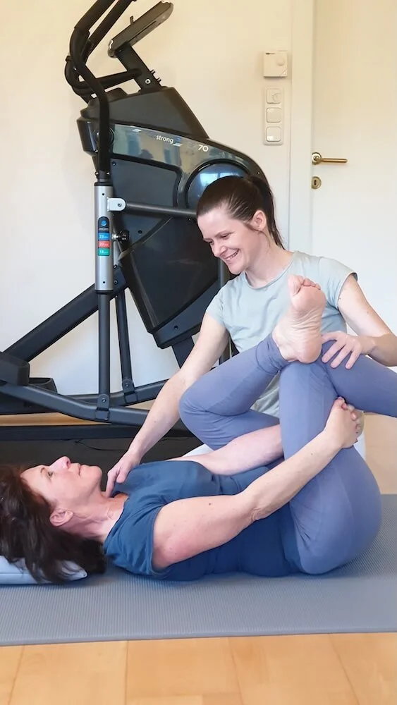 Physiotherapeutin bei einer Bewegungsbehandlung im Trainingsraum