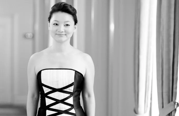 Winnie Wen in an black and white official performance portrait in a gown with a corset-style design.