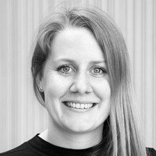 Black and white photo Anna Schjøtt, smiling and with long hair.