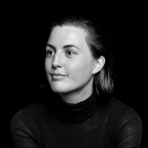 Black-and-white portrait of Dieuwertje Luitse with straight hair, wearing a turtleneck, looking to the side