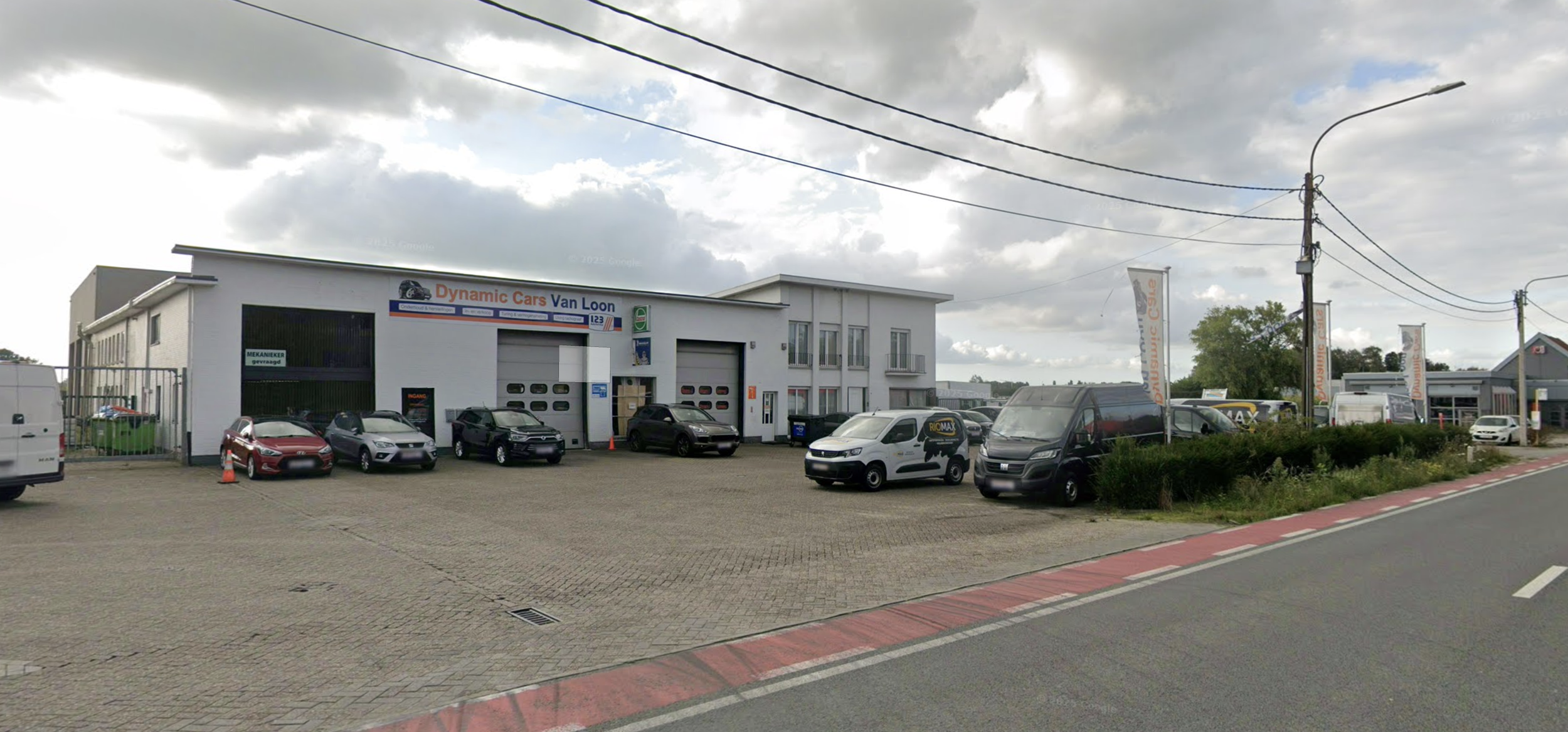 Autos geparkeerd voor een wit gebouw met een bedrijfsnaam 'Dynamic Cars Van Loon'.