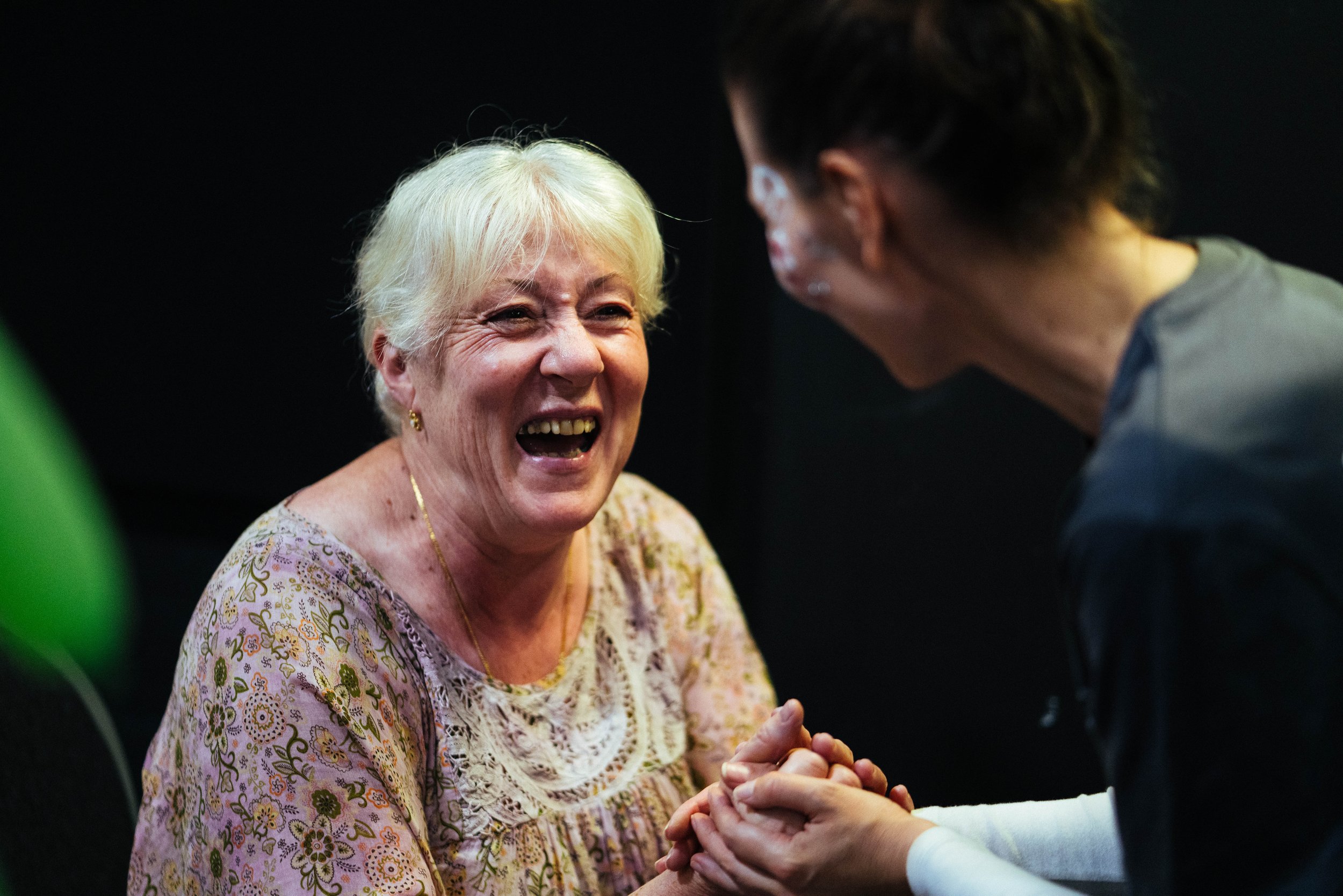 A lady receiving help from a church, she looks happy and is smiling