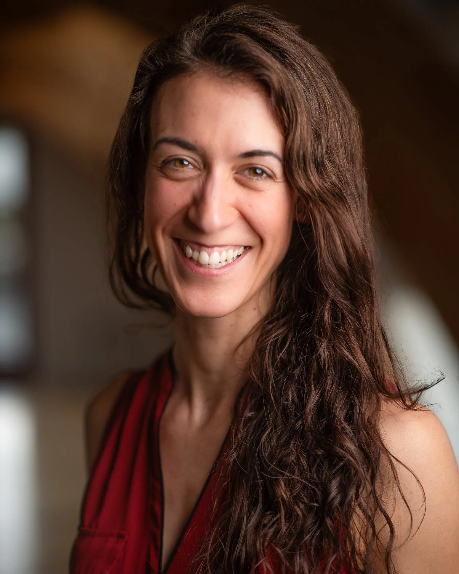 Jennie Rawling, a woman with olive skin and long brown hair, smiles at the camera.