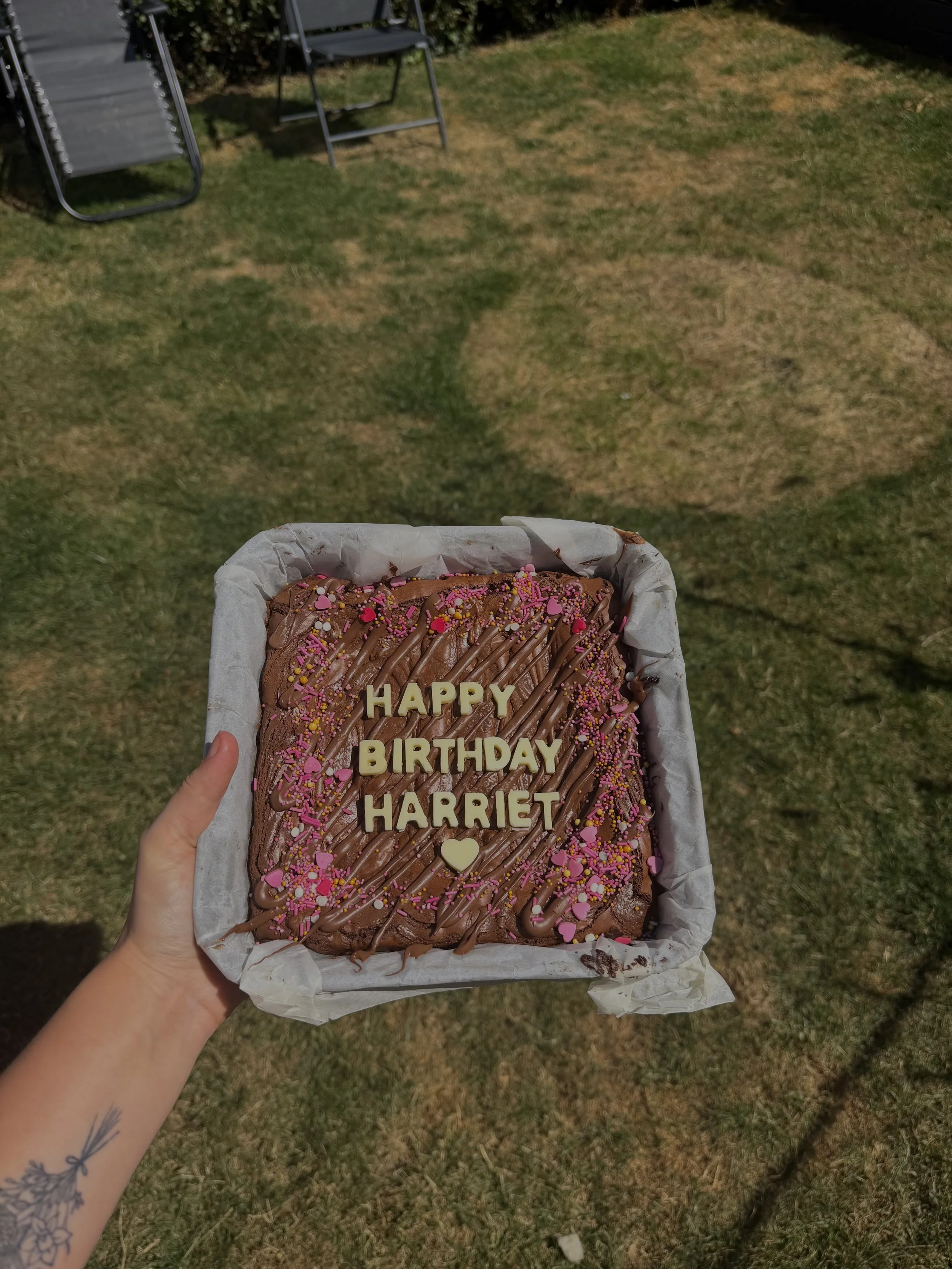 Nutella Brownies with pink and yellow sprinkles, decorated with chocolate drizzle and white letters spelling 'HAPPY BIRTHDAY HARRIET.'