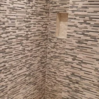 Close-up of tiled shower wall with a built-in niche.