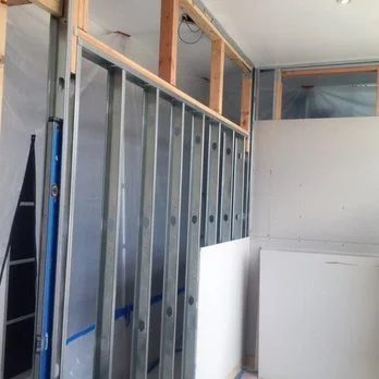 Construction site with metal framing and partially finished walls