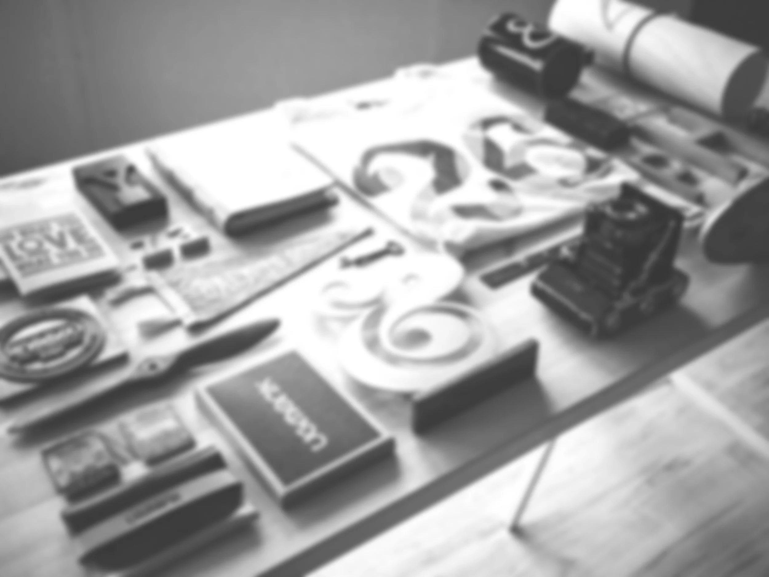 Blurred black and white photograph of various gaming or collectible cards spread out on a surface.