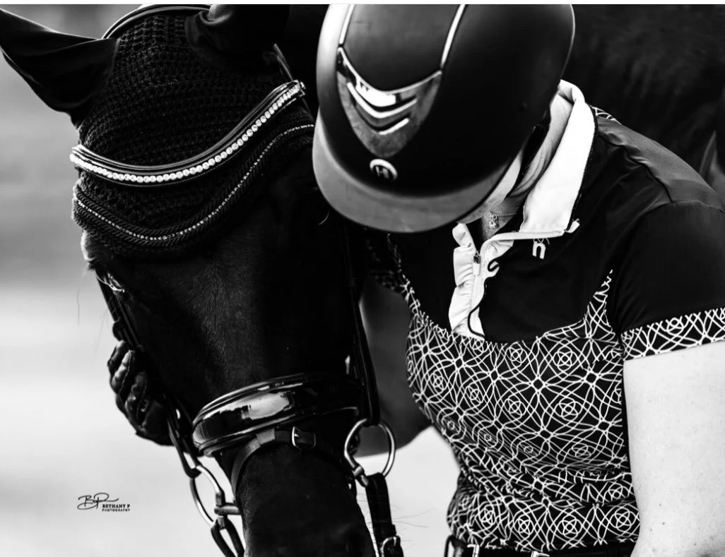 A woman hugging her horse's head 