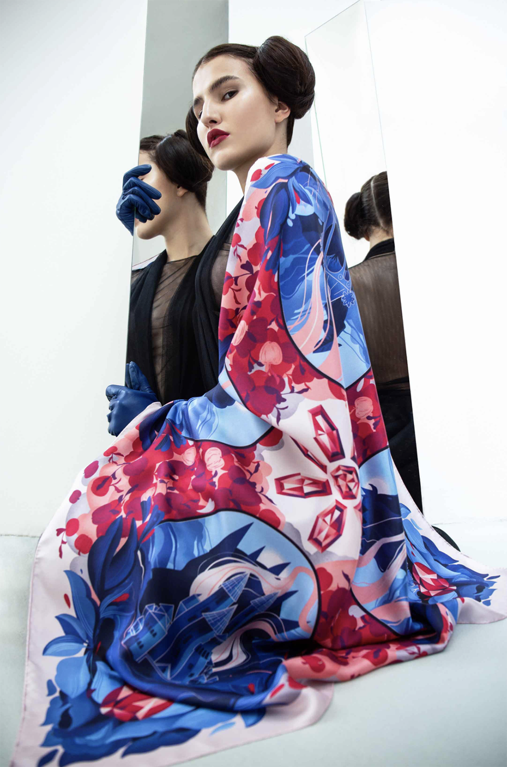 Model posing while wearing a Snow White–inspired scarf featuring ornate mirror motifs and fairytale-inspired apple and jewel patterns.
