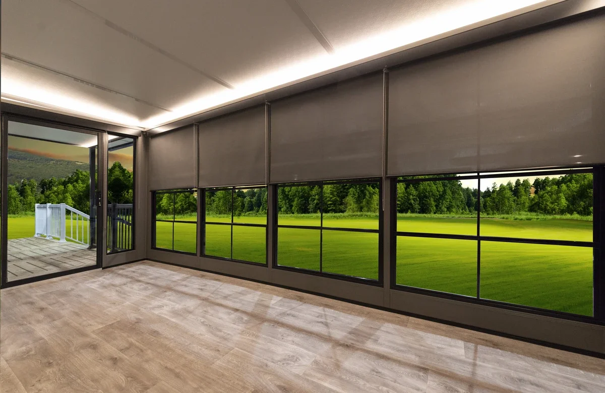Empty room with large windows showing a green outdoor landscape and a glass door leading to a small deck.