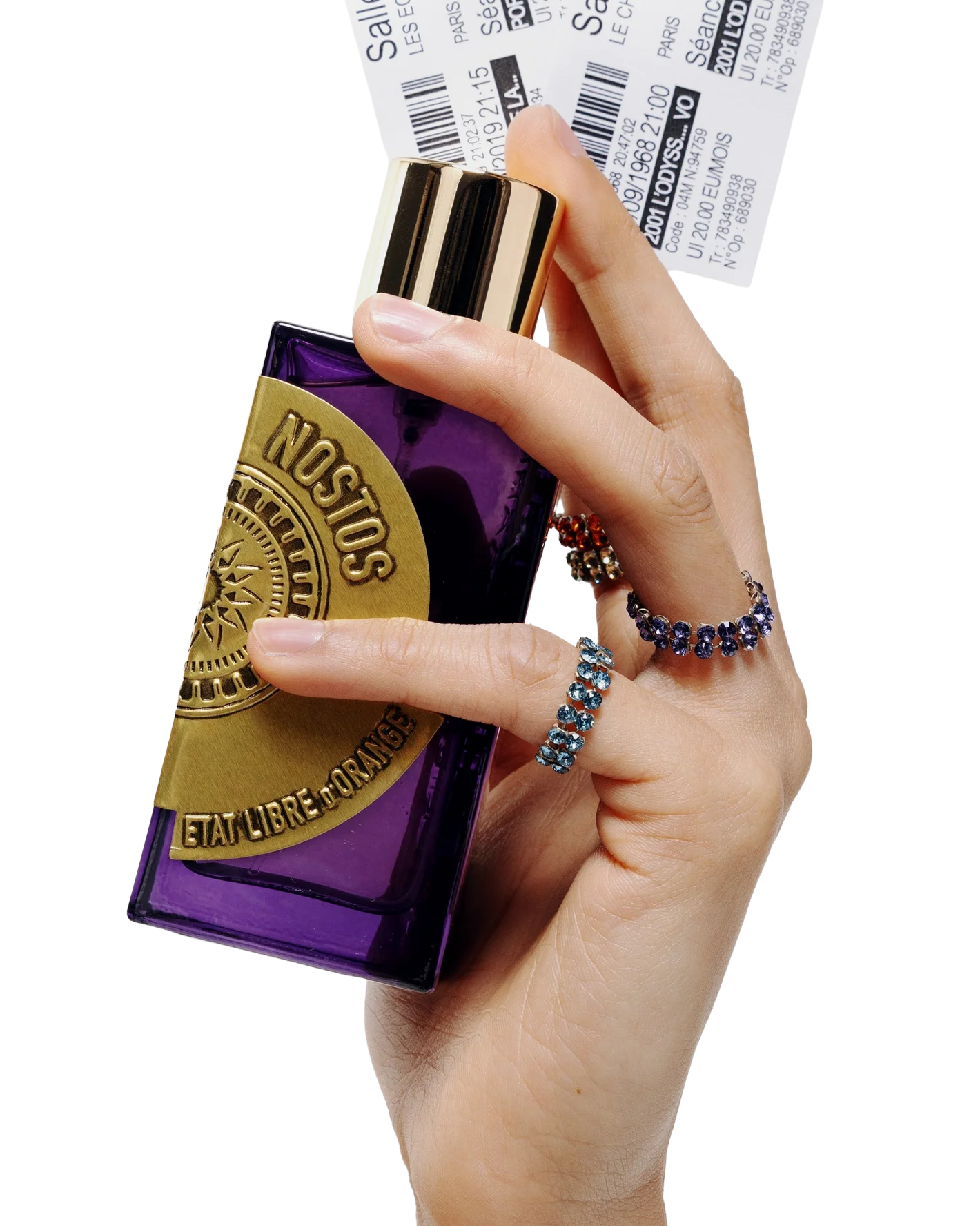 A person's hand holding a purple and gold bottle of Etienne L. Bourdon perfume, with two visible rings on the fingers.