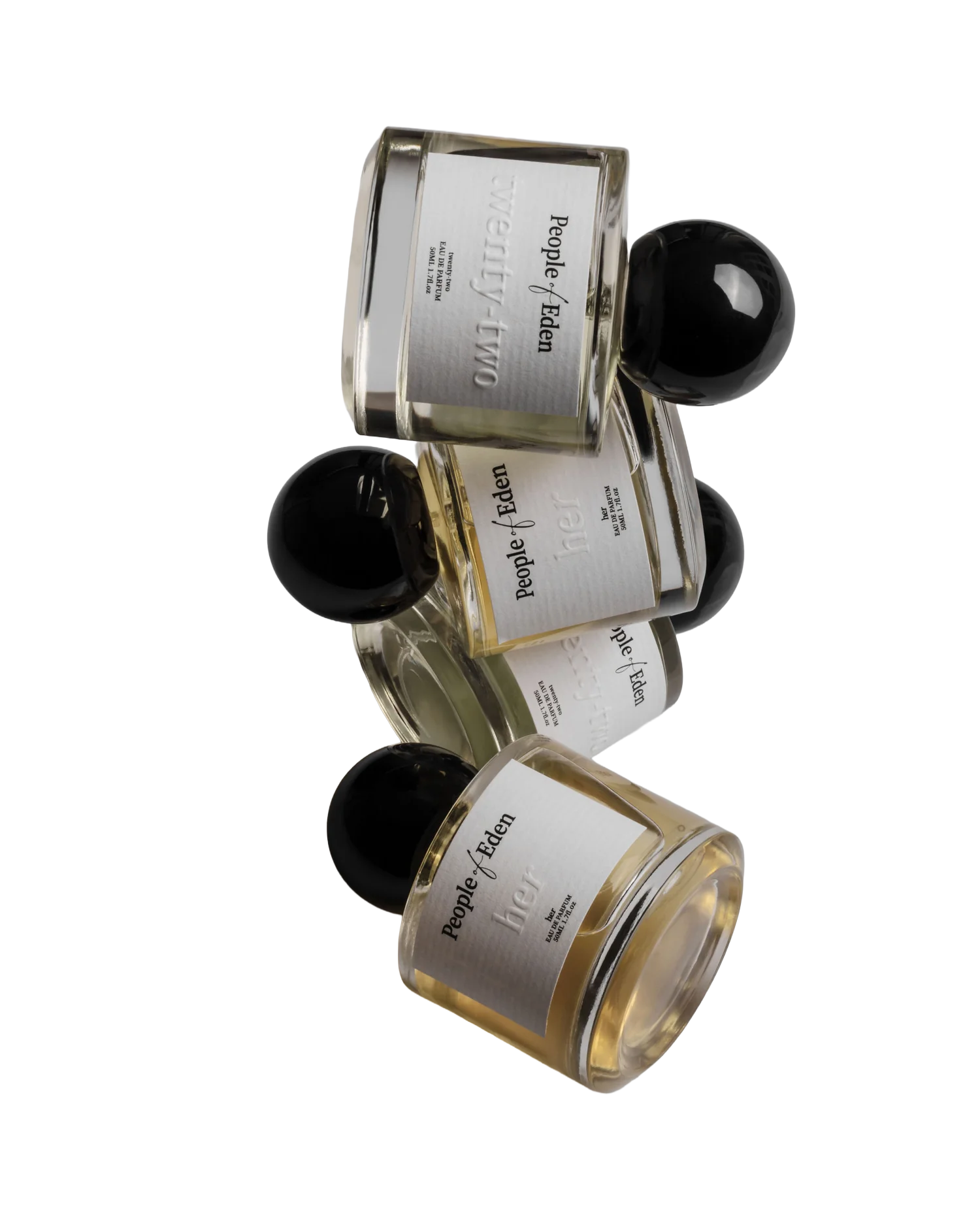 Three bottles of perfume with black caps, positioned at an angle, with white labels that read "People of Eden" and "her."