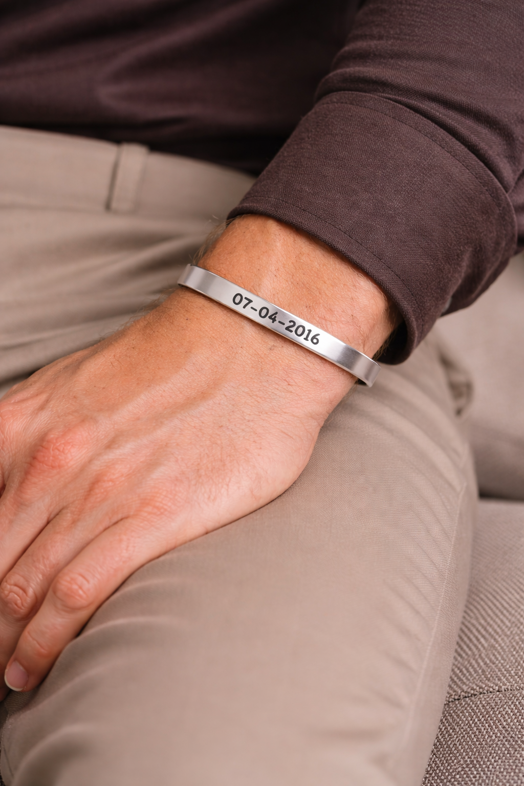 A man wearing our sterling silver classic cuff bracelet with his sobriety date engraved on it. Sobriety date jewelry, recovery gift jewelry