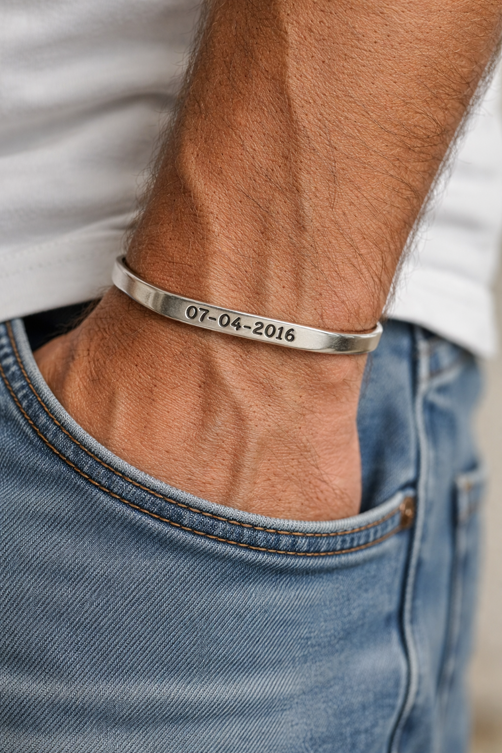 A man wearing our sterling silver angled cuff bracelet with his sobriety date engraved on it.  Sobriety date jewelry, recovery gift jewelry.