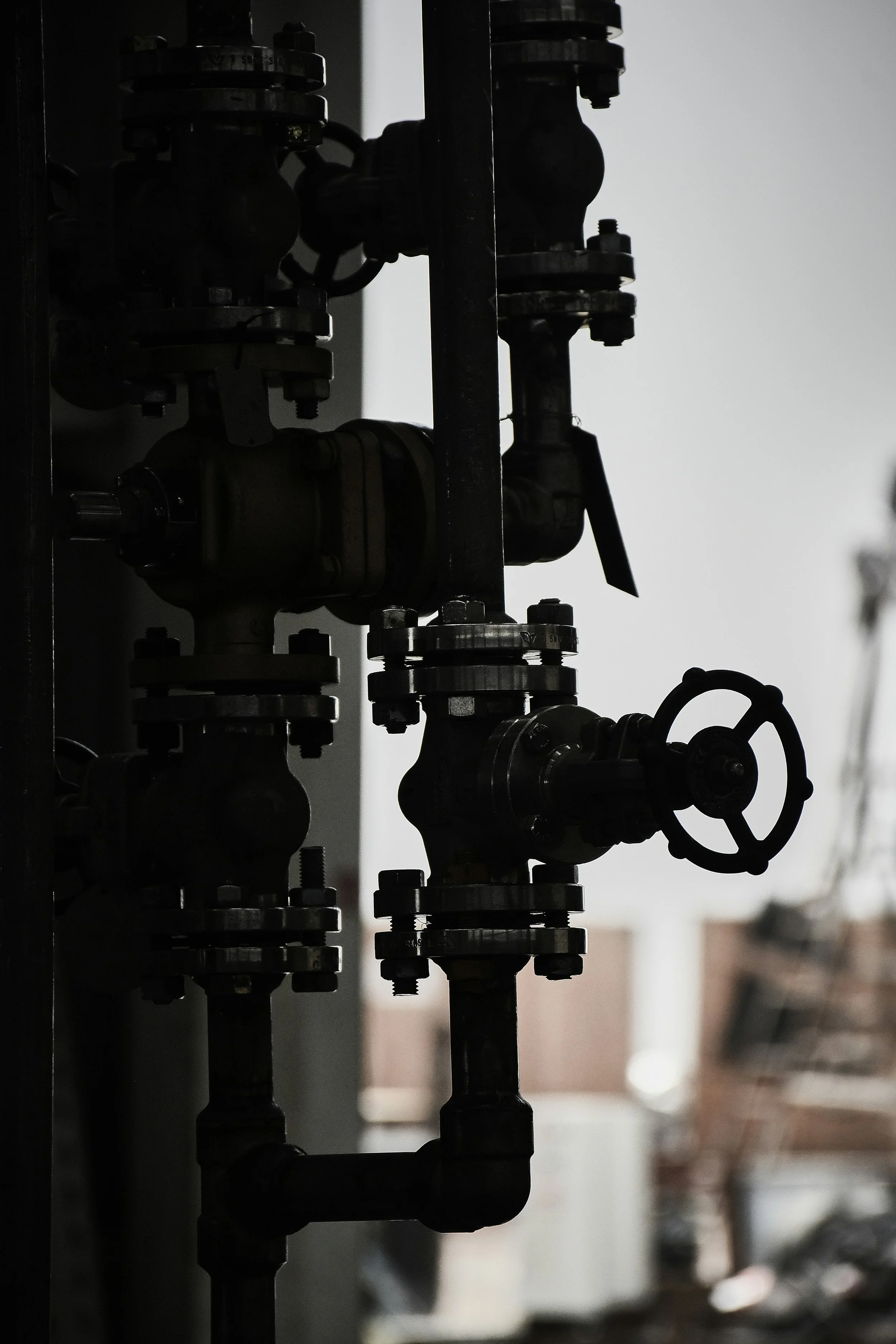 Close-up of industrial piping and valves with a blurred background.