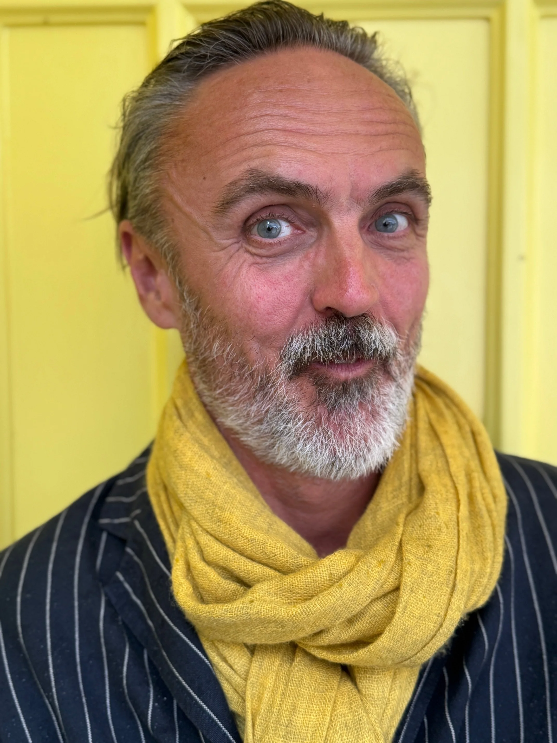 Steve Rawlings, founder of Story of Business, in a yellow scarf and dark pinstripe jacket