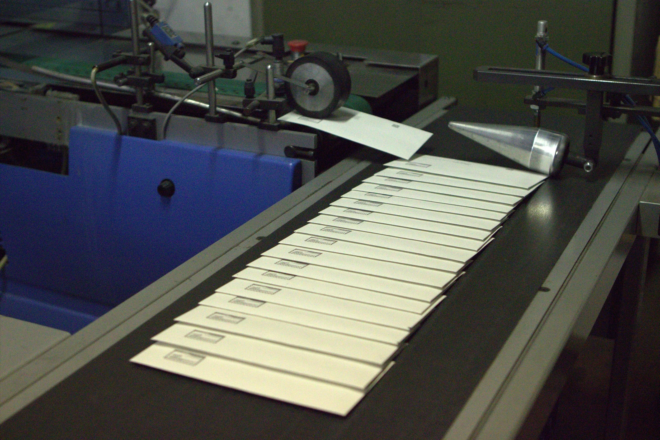 Macchina per l'imballaggio di cassette o cartelline con etichette.
