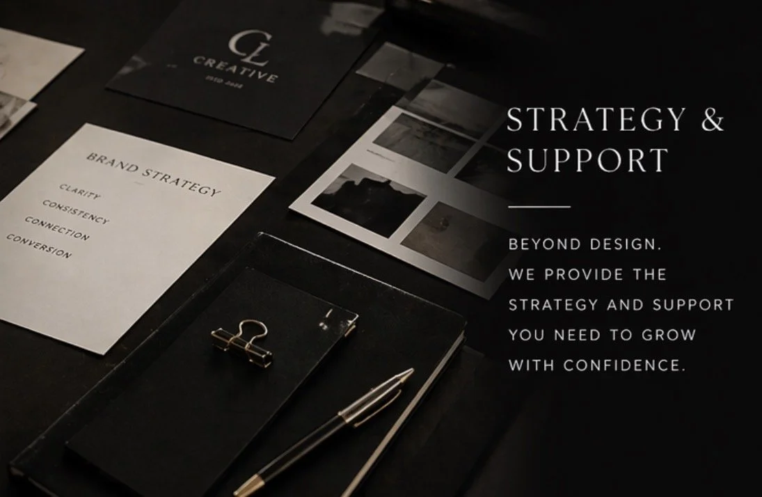 Strategic planning materials including a document titled 'Brand Strategy' with words like clarity, consistency, connection, conversion, a small booklet titled 'Creative,' a computer screen with images, a black tray with a gold binder clip and a gold and black pen placed on top.