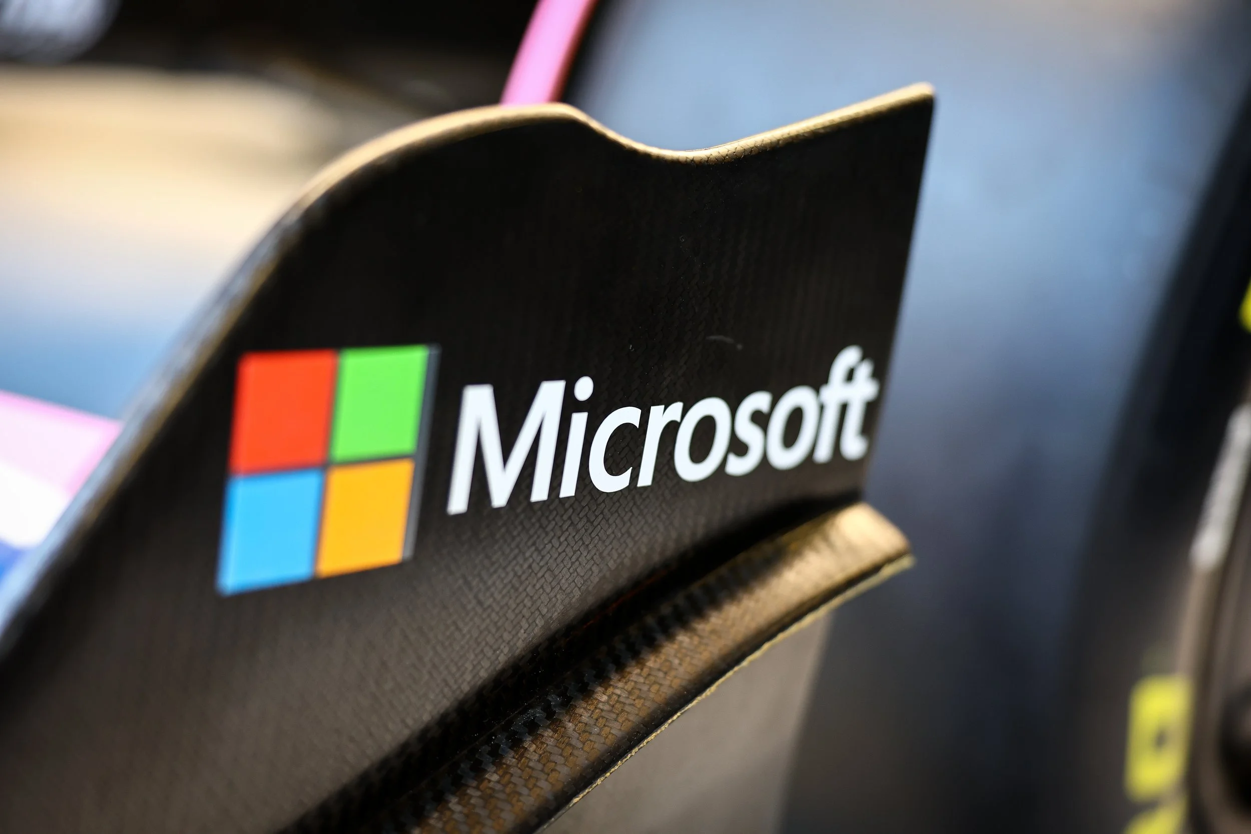 Microsoft logo on the back of a chair, zoomed in in the foreground with blurred office background