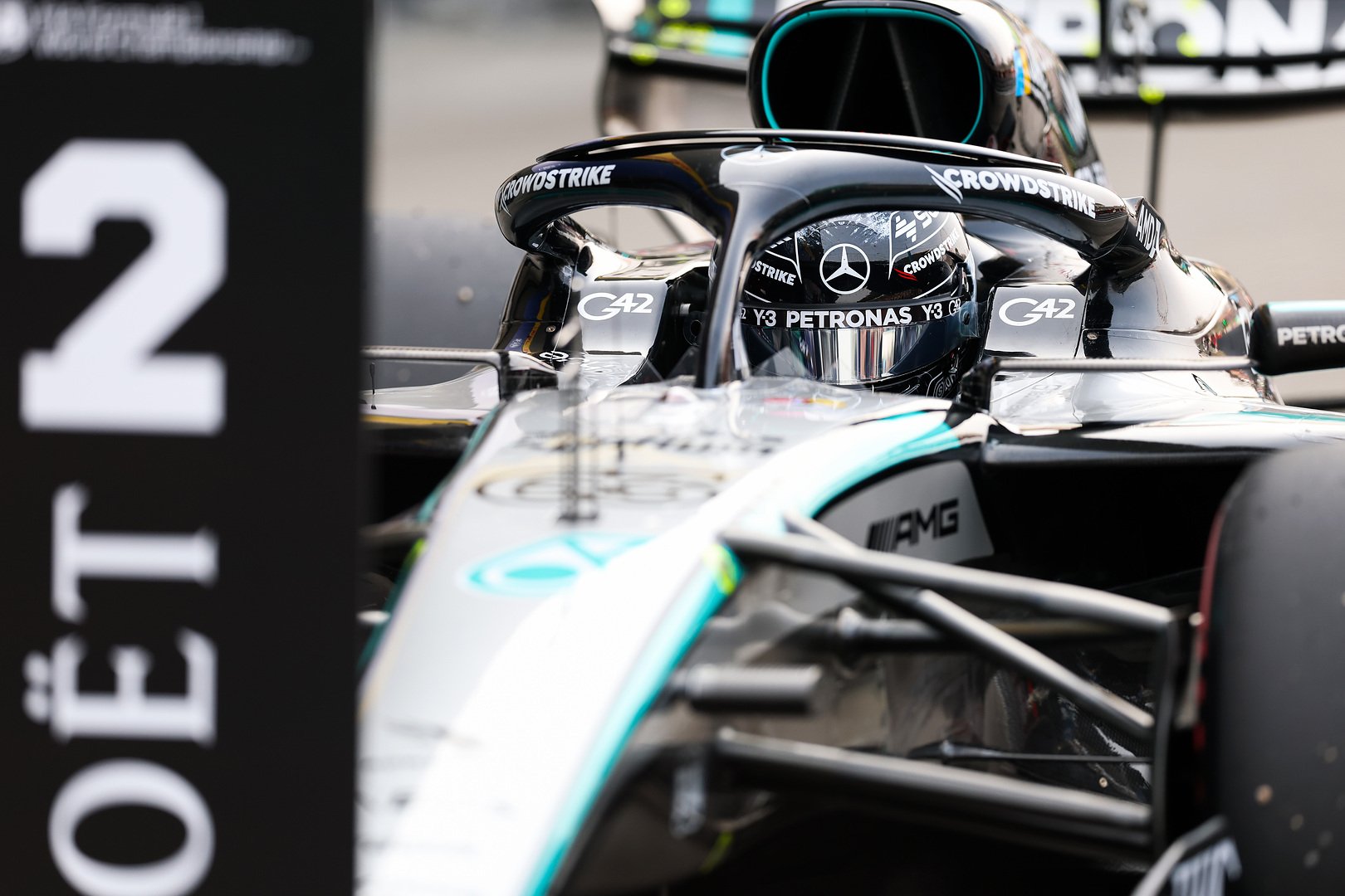 Close-up view of a Mercedes-AMG PETRONAS F1 car entering the pit lane during qualifying at the Japanese Grand Prix, with the number 2 pit board visible in the foreground.