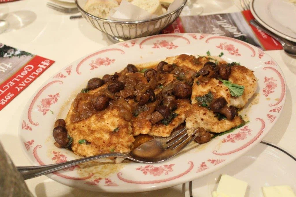 Breaded chicken breast topped with mushroom gravy on a decorative oval plate.