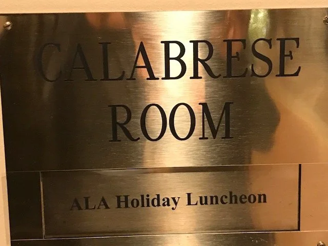 Metal sign that reads 'Calabrese Room' and 'ALA Holiday Luncheon'.