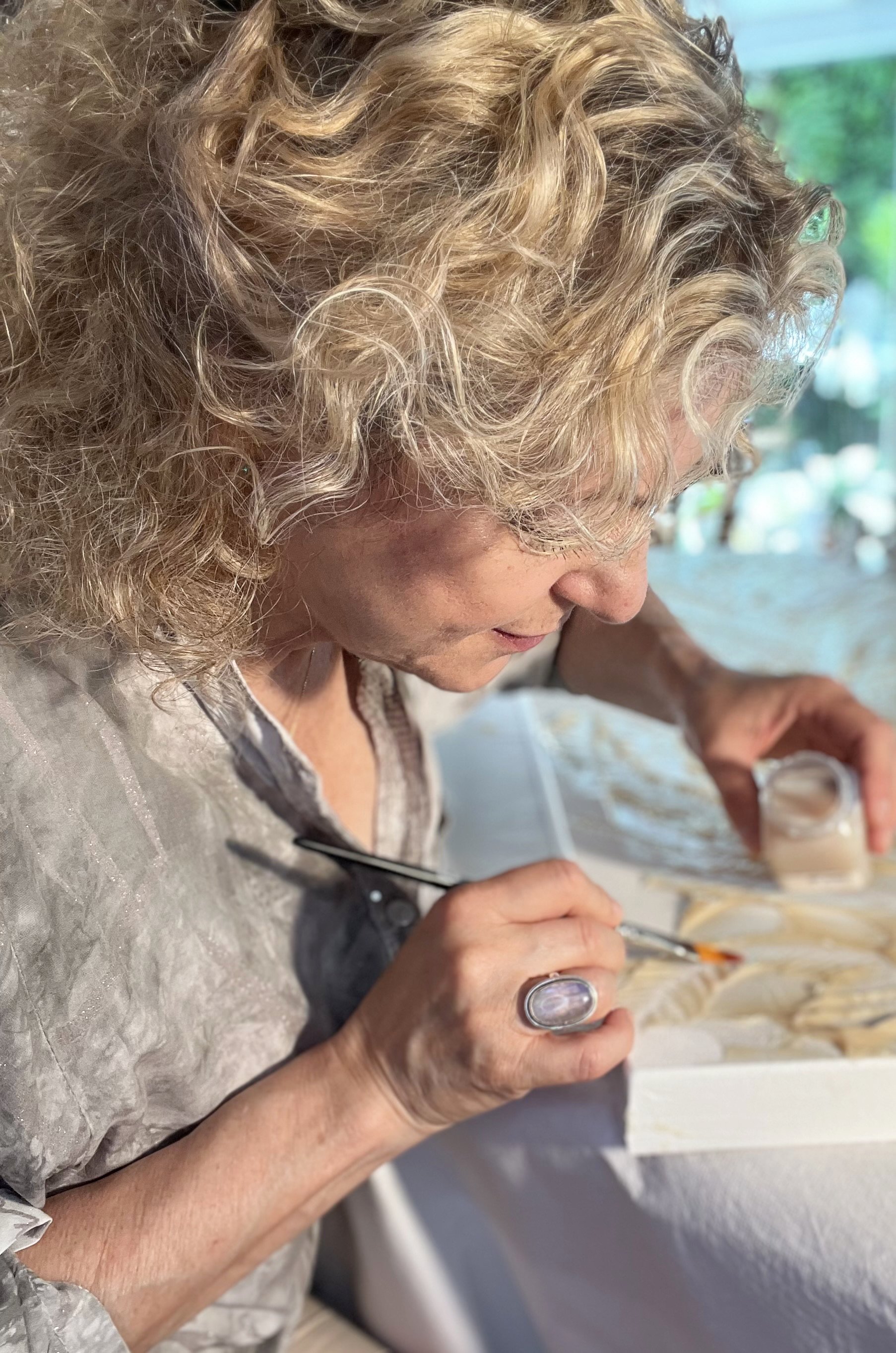 Emanuela Hauth creating an original Auric Art piece with gold leaf and mixed media.