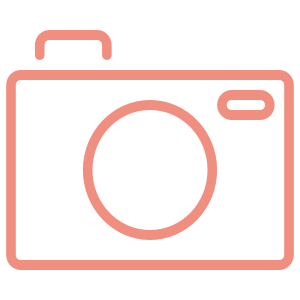 Illustration of a pink camera with a rectangular body, a circular lens, and a small viewfinder on the top right corner.