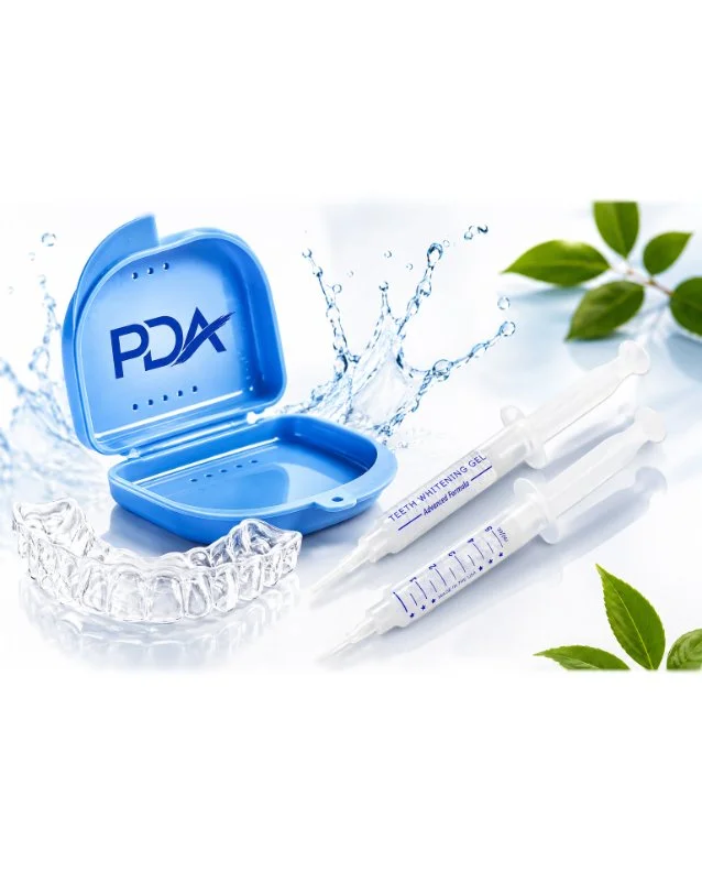 Online teeth whitening kit including a blue container with "PDA" logo, a clear mouth tray, two syringes labeled "Teeth Whitening Gel" with one partially filled, and green leaves in the background.