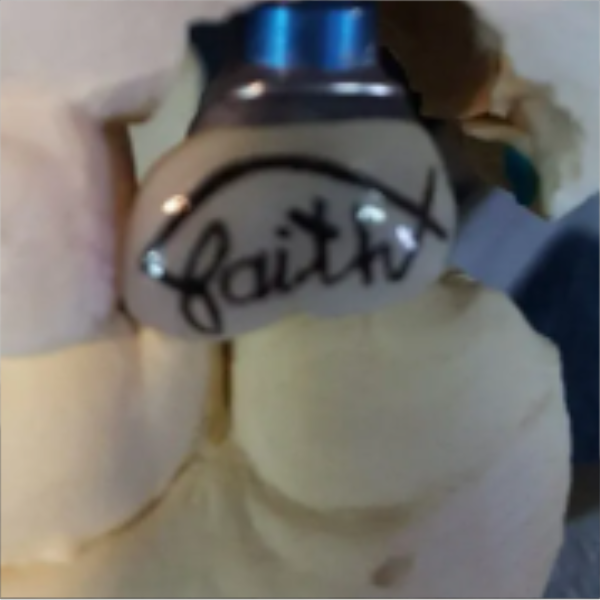 Close-up of a white glove with the word 'Faith' written on it in black ink, holding a blue-capped bottle.