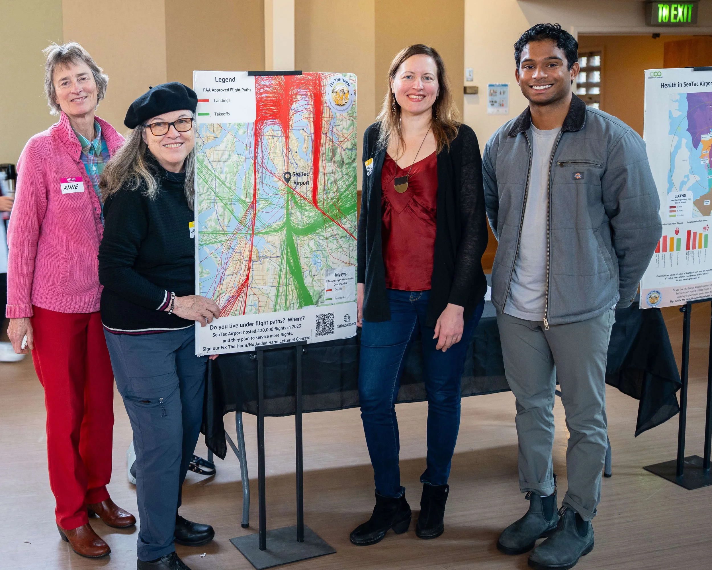 Coalition members and supporters stand in front of a poster with flight paths over South Seattle/South King County.