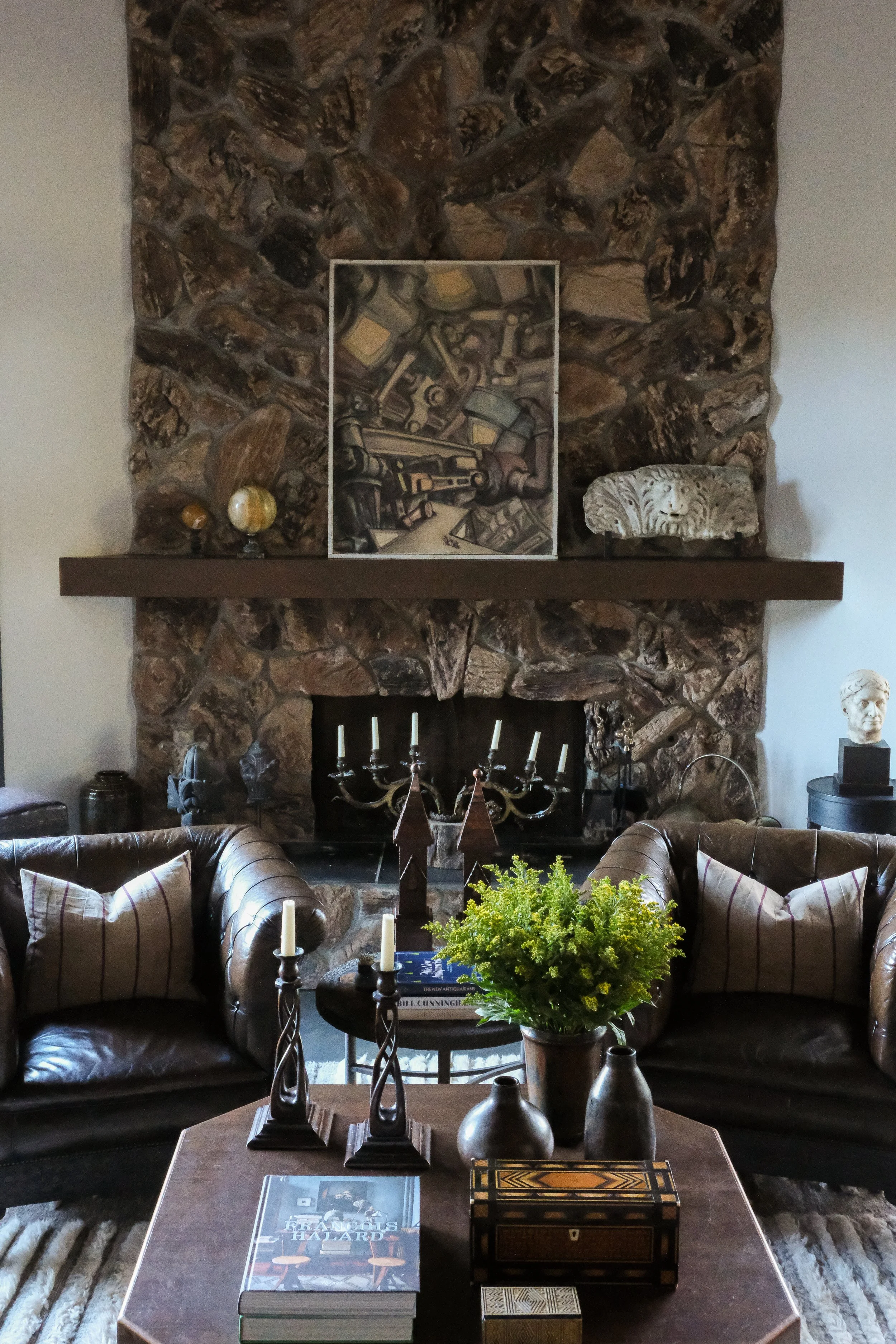 Living room with antique decor and fireplace at Lee Stanton Montecito home