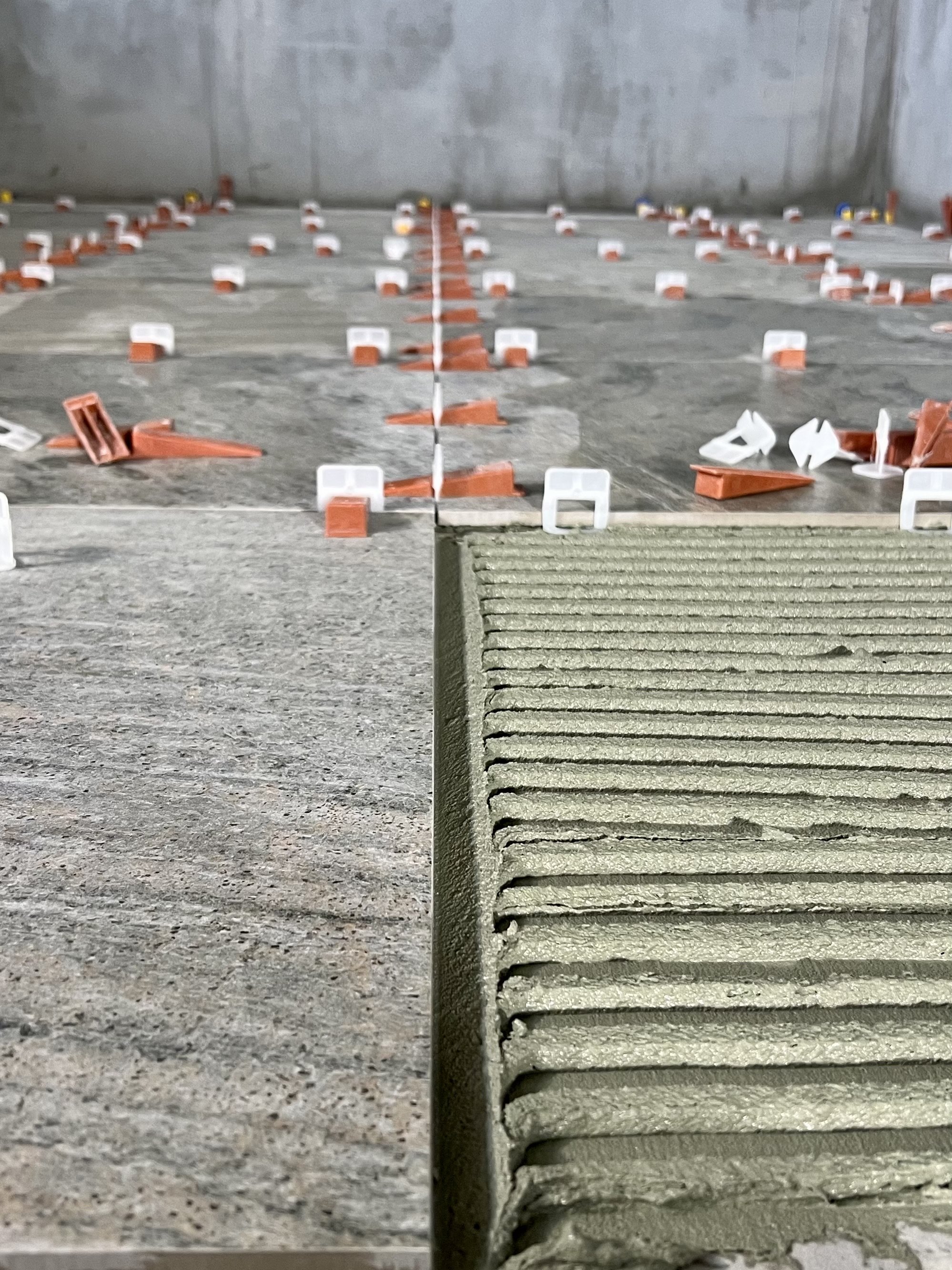 Une pièce de chantier en cours de construction, avec des éléments de béton et des dispositifs de nivellement.