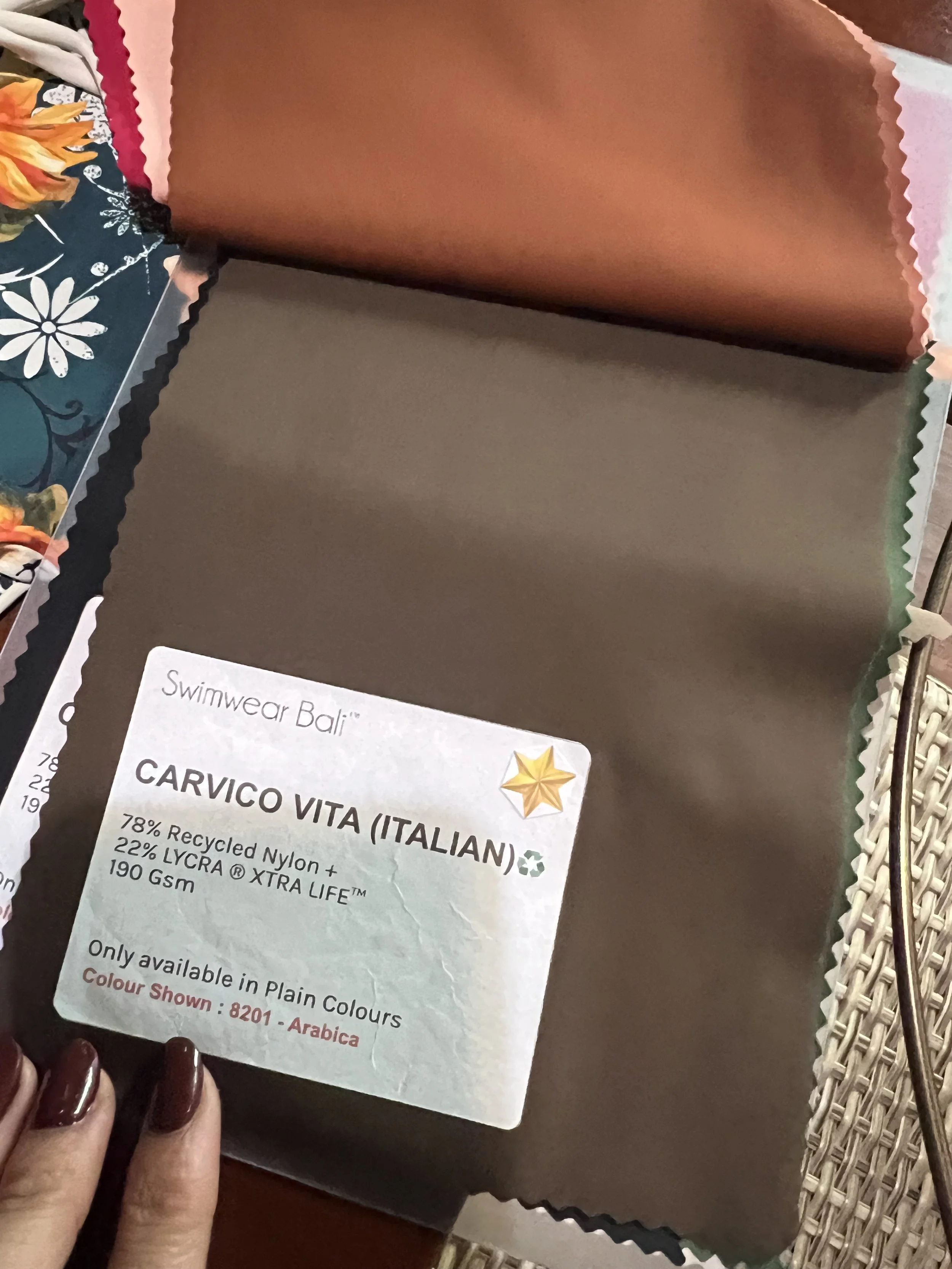 Échantillons de tissu pour maillot de bain, avec une fiche d'information en anglais mentionnant la composition en nylon recyclé, Lycra Xtra Life, 190 Gsm, et la disponibilité uniquement en couleur unie naturelle.