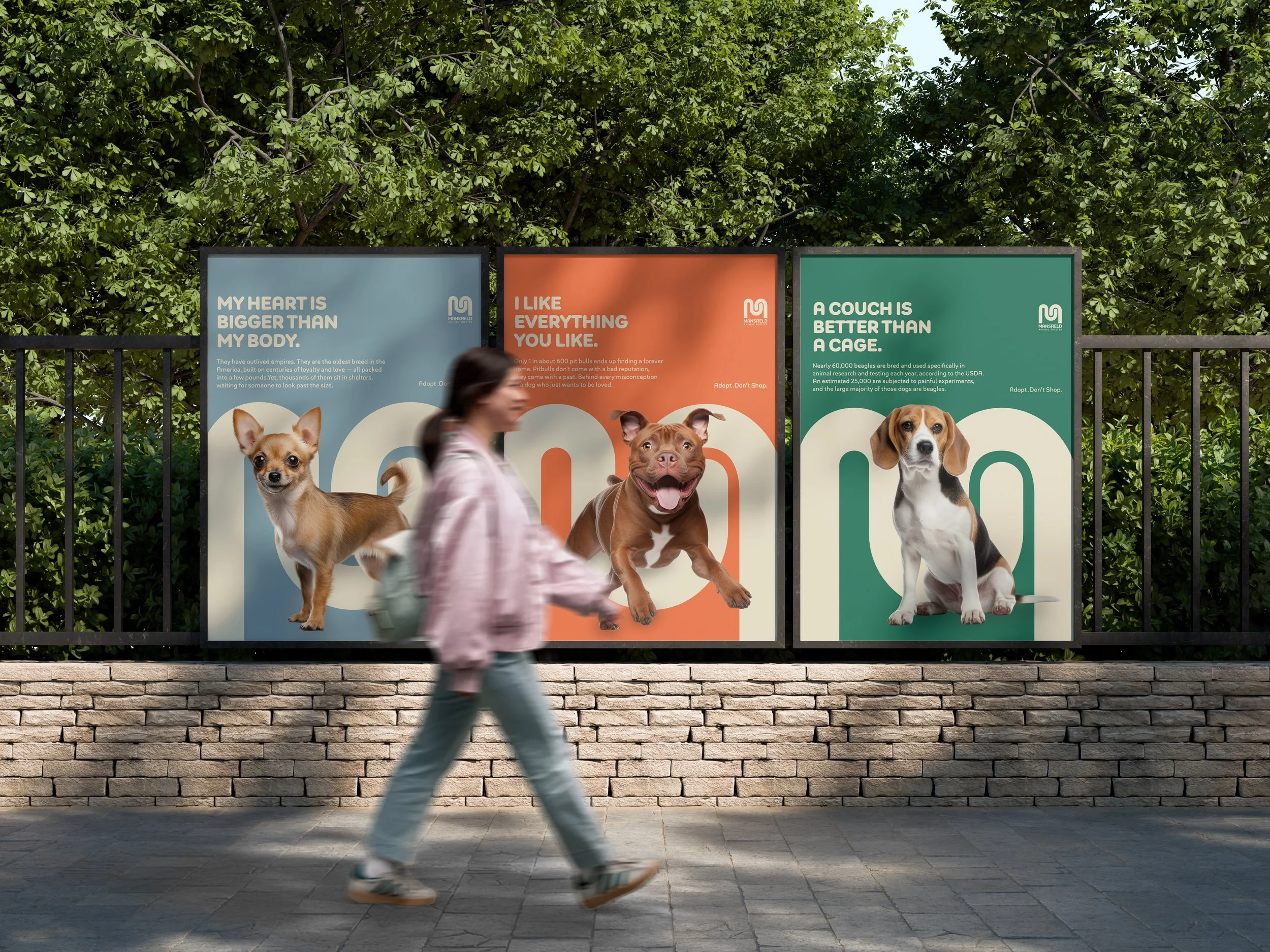 People walking past three large advertisements for dogs, each featuring a different breed and a message about dogs and their needs, with trees in the background.