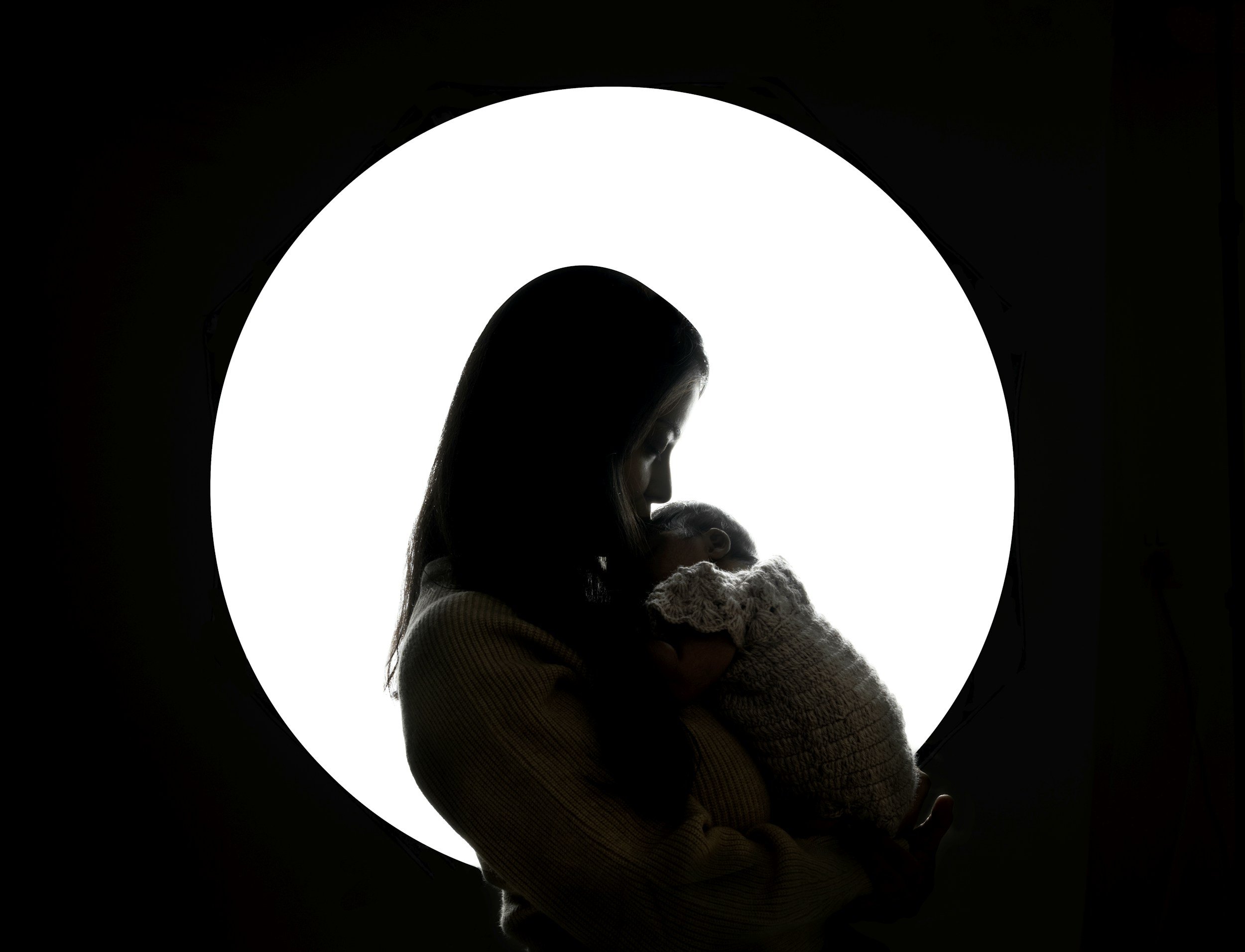 A woman with possible postpartum depression holding her newborn baby