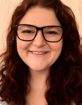 A woman with curly brown hair and glasses smiling, against a geometric teal and beige background.