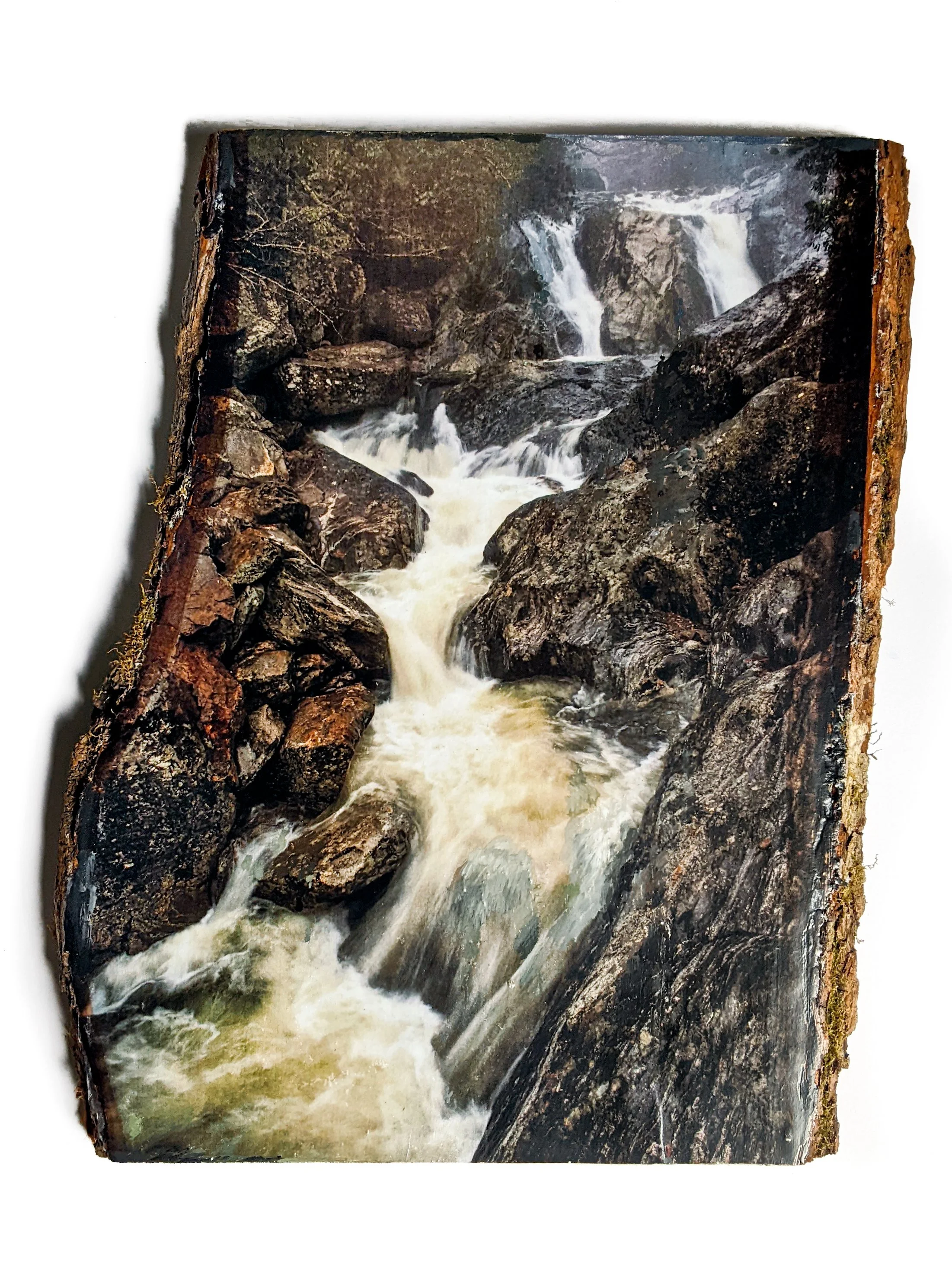 Photograph of a waterfall with rocks in a forest setting.