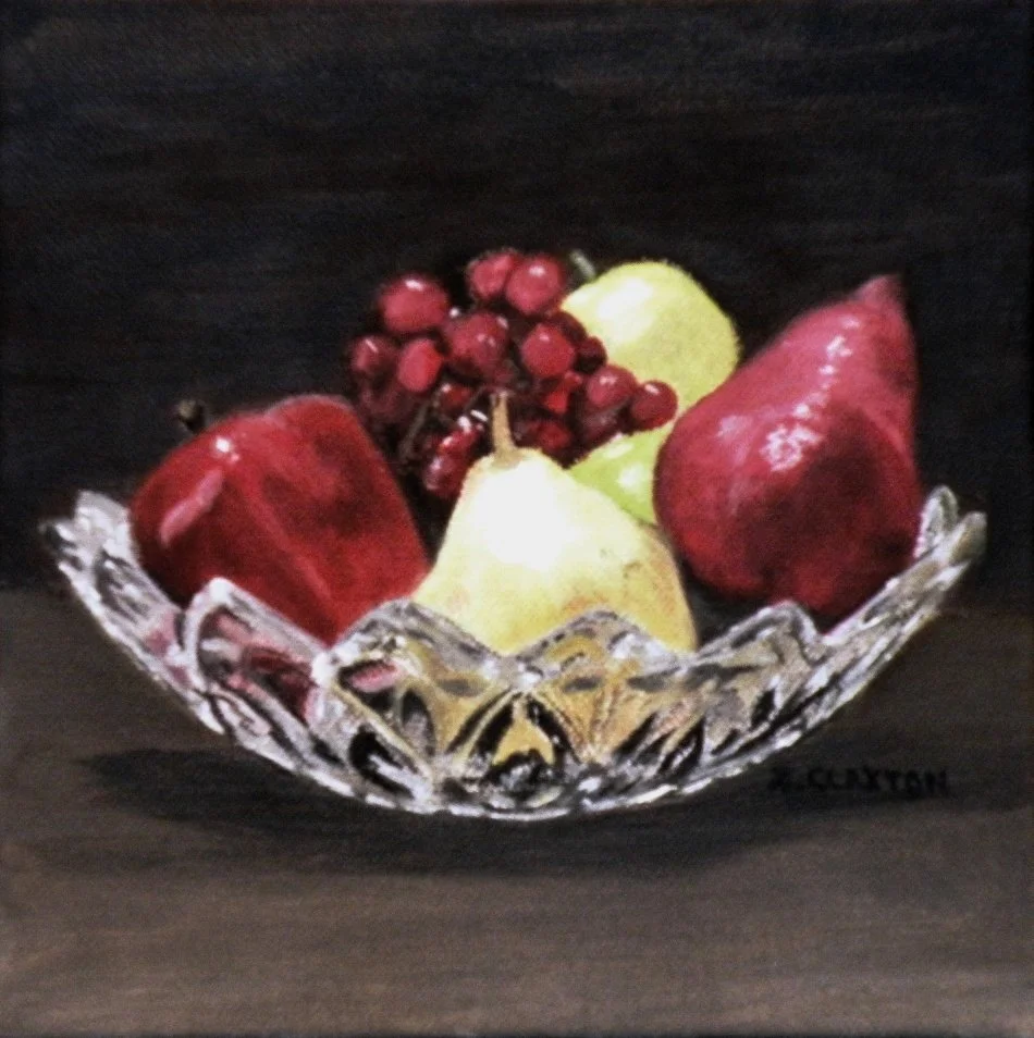 A decorative glass bowl holding red apples, green pears, red grapes, and a red bell pepper, placed against a dark background.