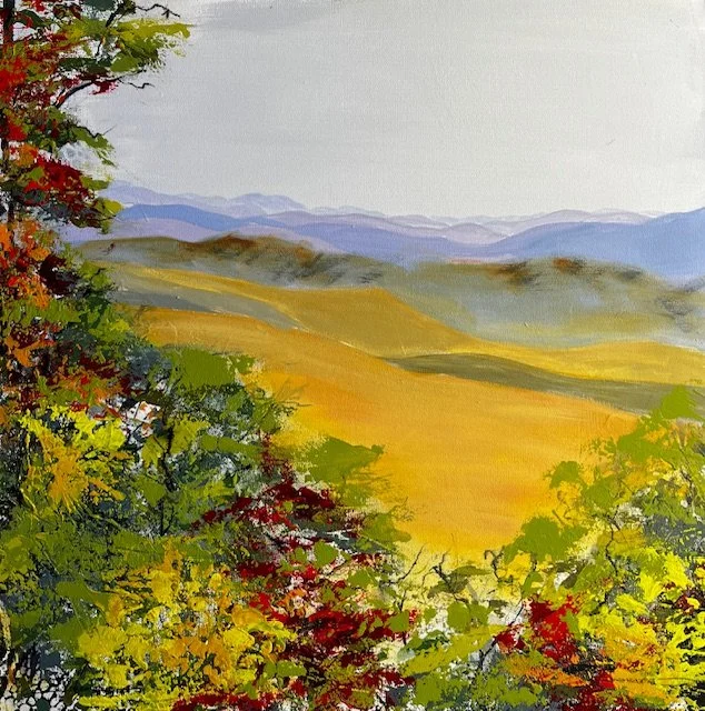 Watercolor painting of rolling hills with yellow fields, distant mountains, and trees with red, green, and yellow leaves in the foreground.