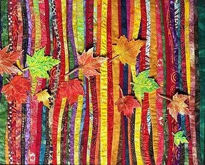 Colorful fabric background with faux autumn leaves scattered on top.