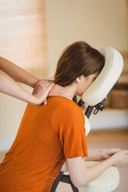 A woman receiving on site chair massage in an office.