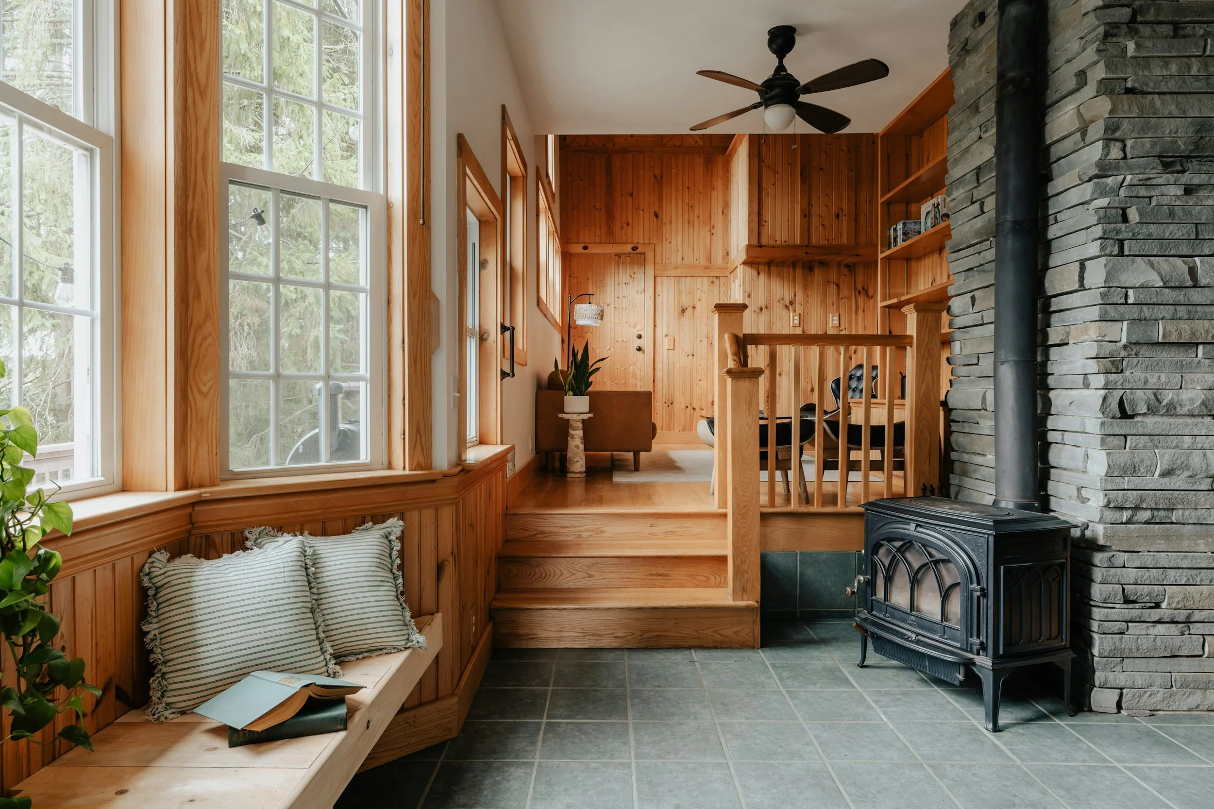 Cabin styled home with wood paneling and wood stove