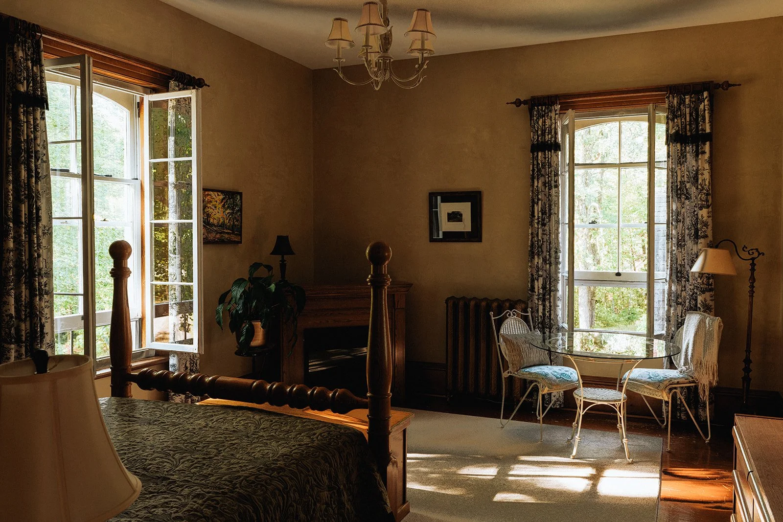 Open photo album on wooden table, showing a picture of a red vintage car outside with trees and grass, and interior shots of a dark room with a piano and a person sitting by a window.