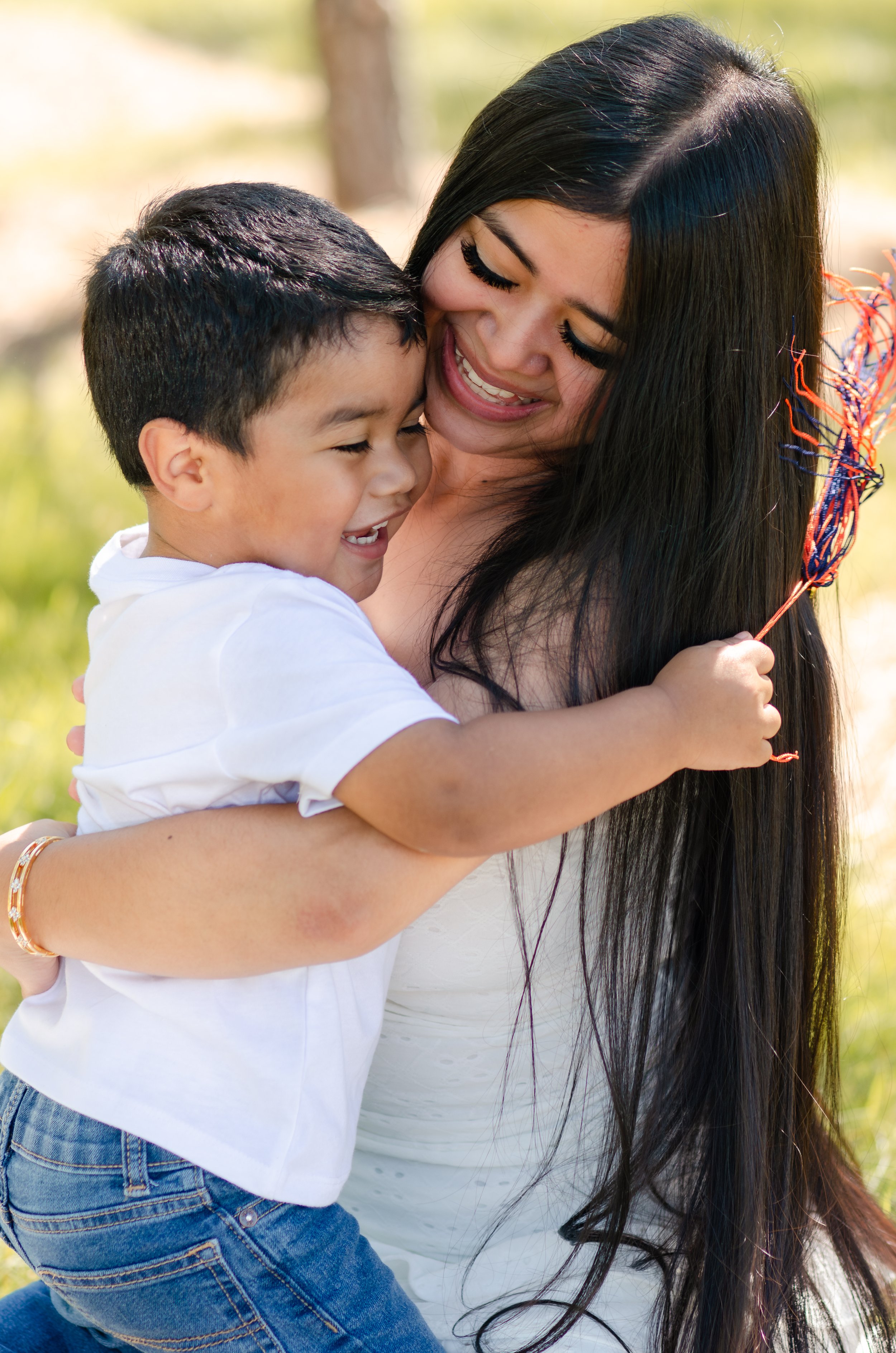  Outdoor motherhood photography capturing a loving mom cuddling her toddler son at golden hour   