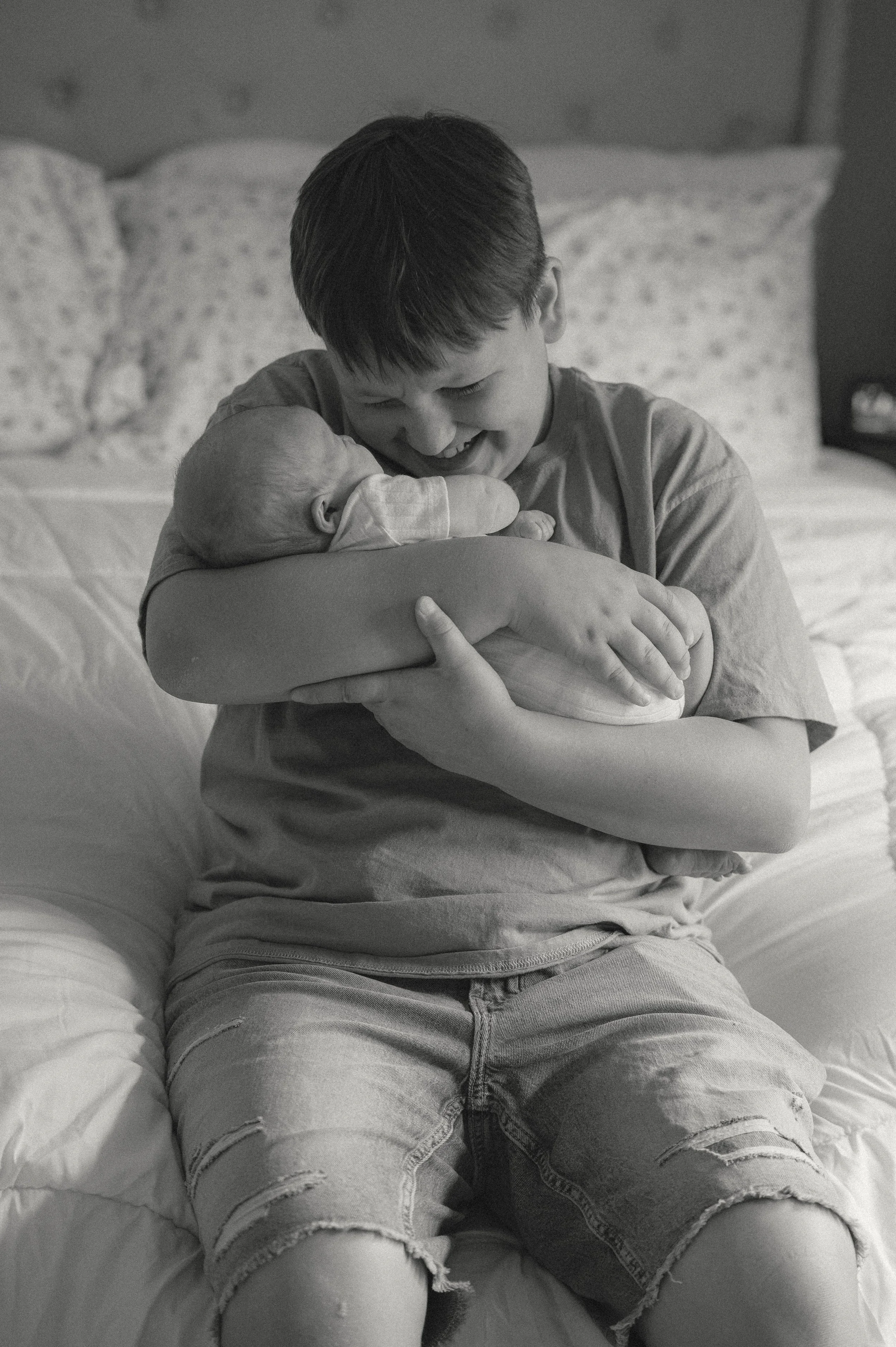 Candid photos with older brother and his newborn baby brother captured by a maryville newborn photographer in east Tennessee